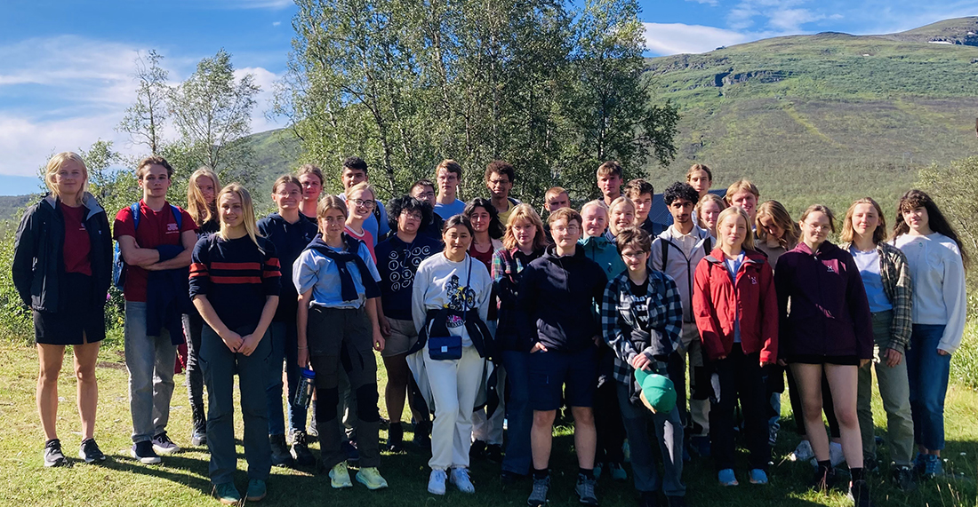 Gruppbild utomhus i sol.