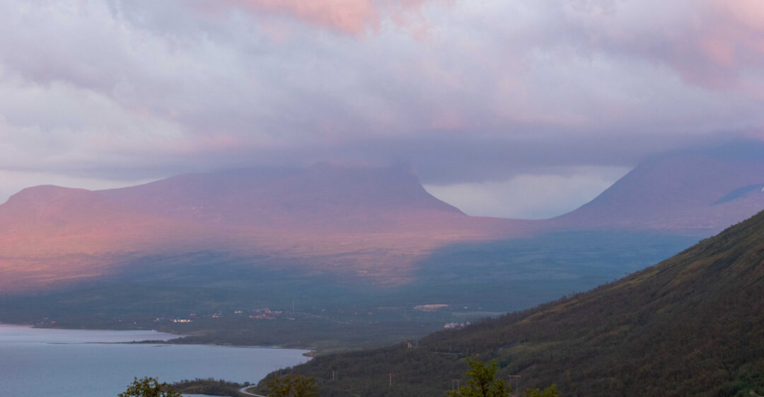 BIld: fjällnatur med rosa slöjmoln, bergformation Lapporten i fonden, sjö till vänster.