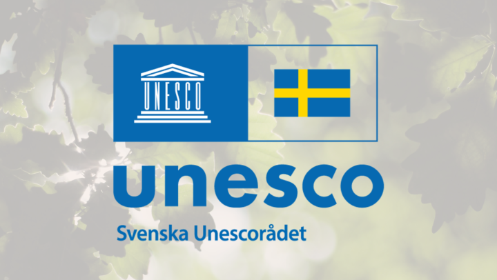 Logotyp på bakgrund med eklöv där sol strilar igenon.