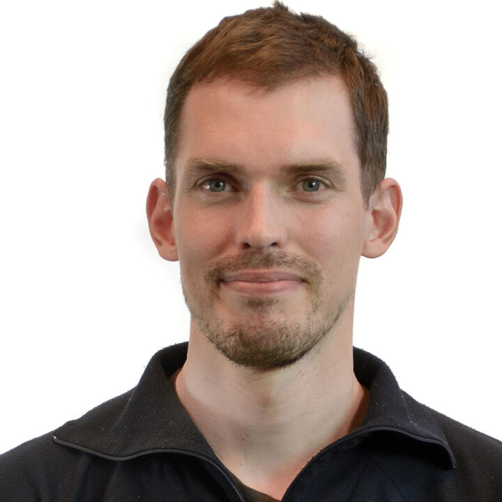 Bild: frilagt inomhusporträtt av småleende man