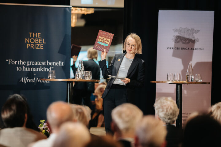 Bild: Sofia Lodén håller upp barnbok på scen