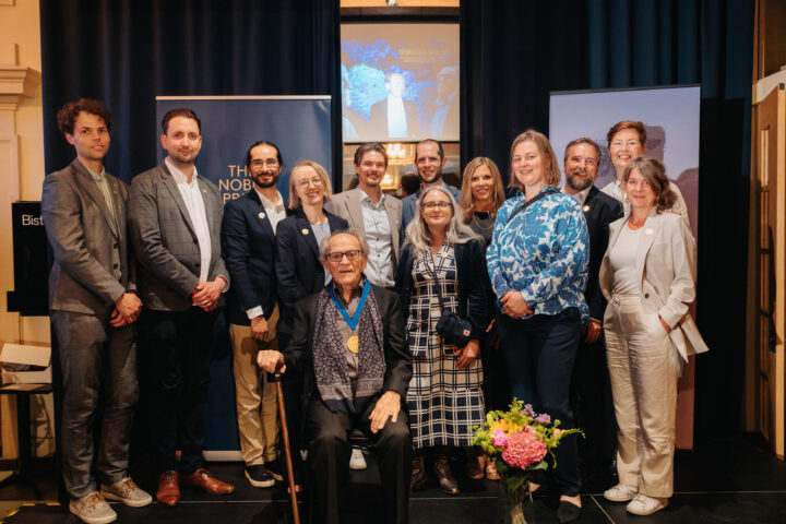 SUA-ledamöter och staff samlade till gruppbild runt sittande Nobelpristagare