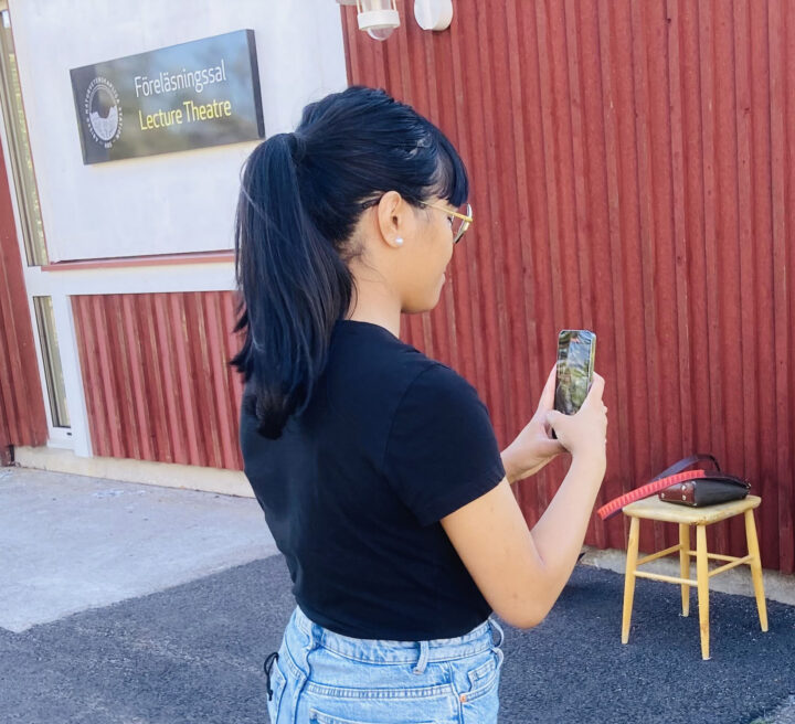 Bild: Tjej sedd snett bakifrån filmar videointervju med mobilen