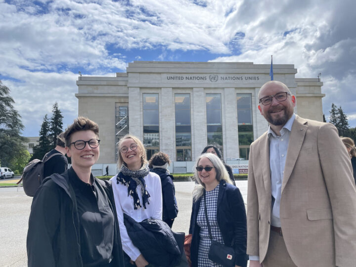 Bild: fyra personer framför FN-byggnad i Genève